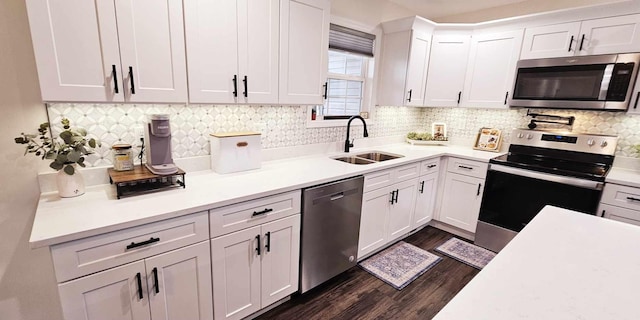 kitchen featuring appliances with stainless steel finishes, dark hardwood / wood-style floors, white cabinetry, sink, and backsplash