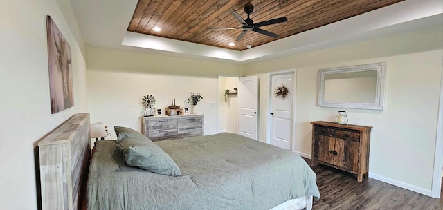 bedroom featuring ceiling fan, a tray ceiling, dark hardwood / wood-style flooring, and wooden ceiling