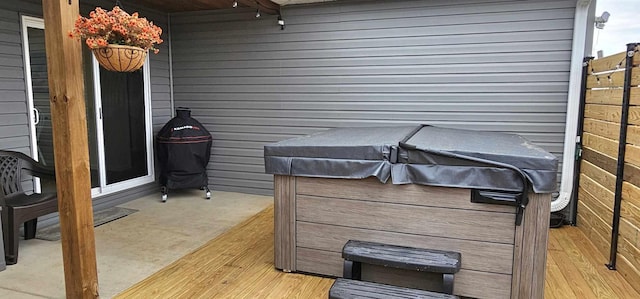 view of patio with a hot tub and a deck