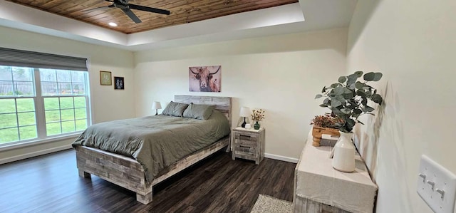 bedroom with dark hardwood / wood-style flooring, wood ceiling, a raised ceiling, and ceiling fan