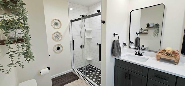 bathroom with hardwood / wood-style flooring, vanity, and a shower with shower door