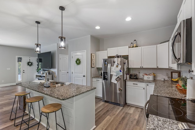 123 Tommy Loop, Sweetwater, TN 37874 - kitchen with appliances with stainless steel finishes, a sink, light wood-style floors, tasteful backsplash, and stone counters
