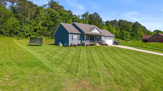123 Tommy Loop, Sweetwater, TN 37874 - view of front of home with a trampoline, a porch, driveway, an attached garage, and a front lawn
