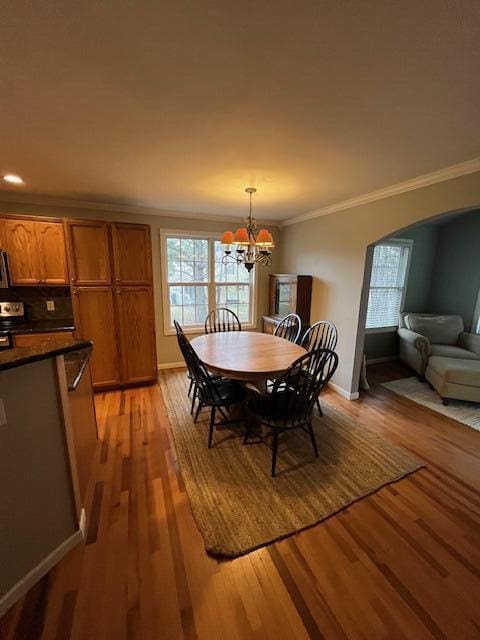 dining room featuring a notable chandelier, light wood-type flooring, and ornamental molding