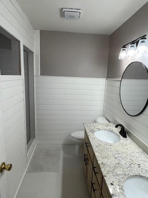 bathroom with a shower, tile patterned flooring, vanity, and toilet