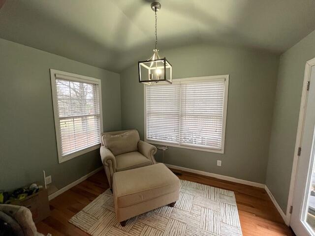 sitting room with light hardwood / wood-style flooring, a chandelier, and lofted ceiling