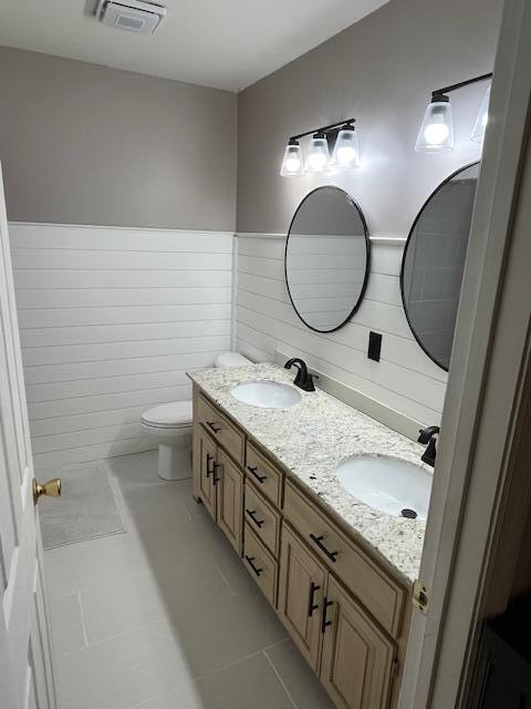 bathroom featuring toilet, vanity, and tile patterned floors