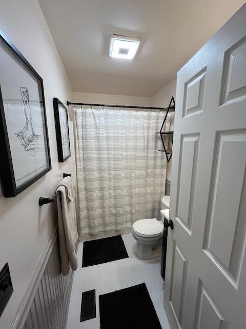 bathroom with tile patterned flooring, vanity, toilet, and a shower with shower curtain