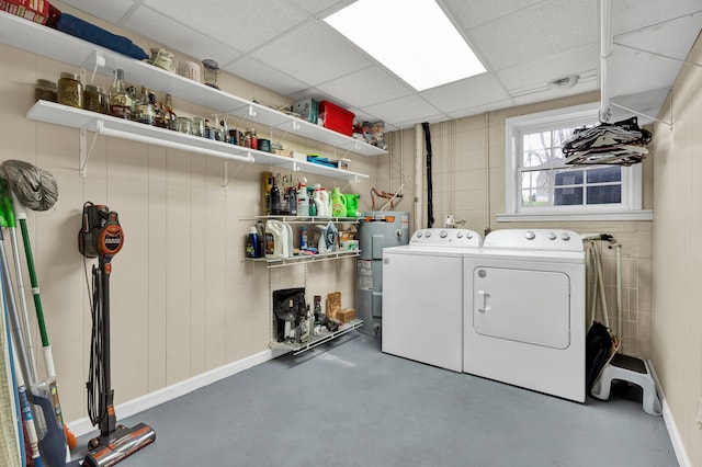 laundry room featuring water heater, baseboards, washer and dryer, and laundry area