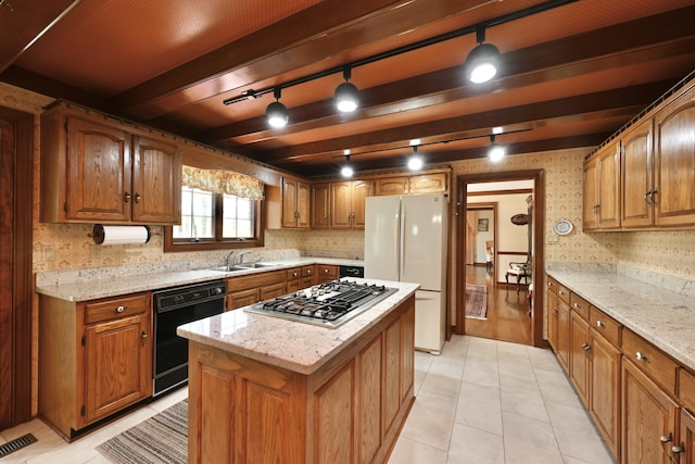 kitchen featuring a sink, stainless steel gas stovetop, dishwasher, visible vents, and freestanding refrigerator