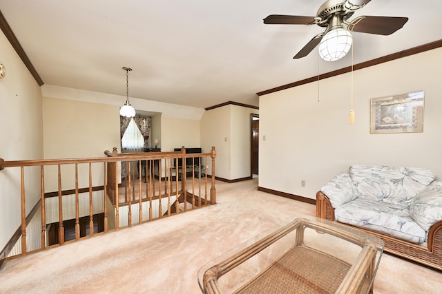 living area featuring a ceiling fan, baseboards, light colored carpet, and crown molding