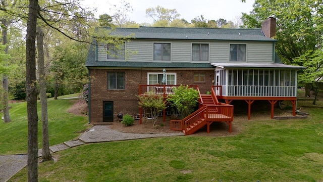 rear view of house with stairway, a chimney, a yard, brick siding, and a sunroom