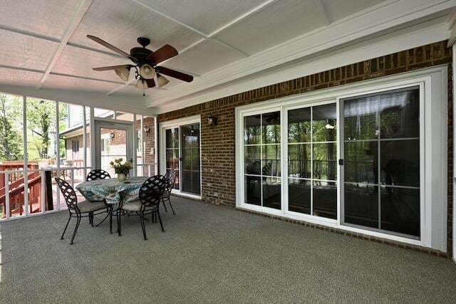 sunroom with ceiling fan and outdoor dining area