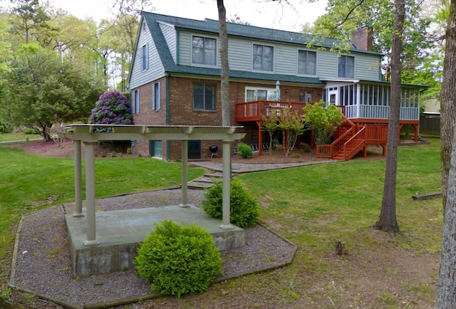 rear view of house featuring a patio area, stairs, a deck, brick siding, and a sunroom