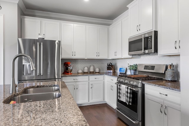 kitchen featuring tasteful backsplash, white cabinetry, sink, light stone counters, and stainless steel appliances