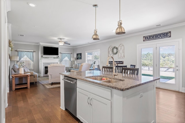 kitchen featuring sink, dishwasher, hanging light fixtures, light stone counters, and white cabinets