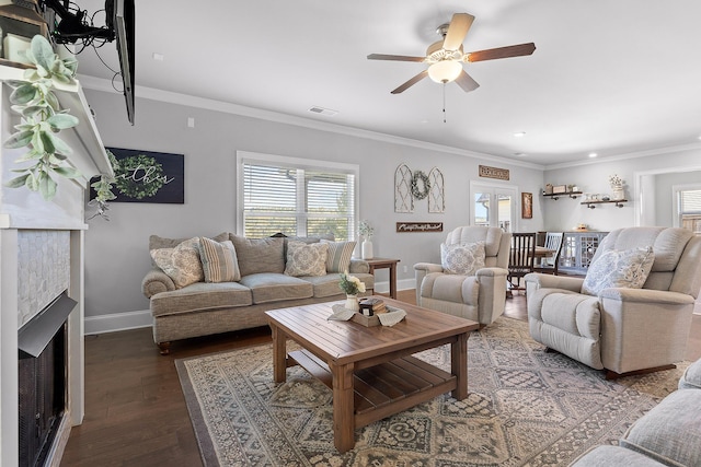 living room featuring crown molding, a healthy amount of sunlight, and dark hardwood / wood-style flooring