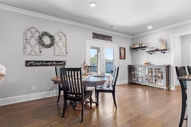 dining space featuring dark wood-type flooring and ornamental molding