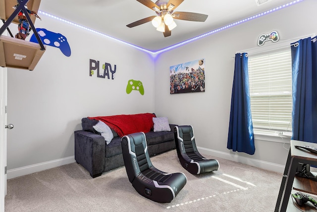 living area featuring ceiling fan and carpet