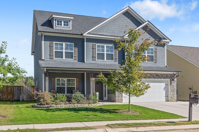 craftsman house featuring a garage, covered porch, and a front yard