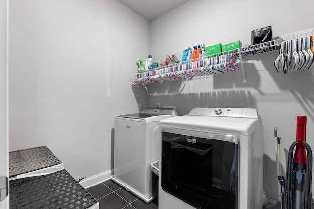 laundry area featuring washing machine and clothes dryer and dark tile patterned flooring