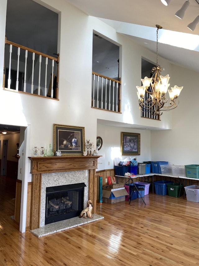 living room featuring a fireplace, a high ceiling, and wood finished floors