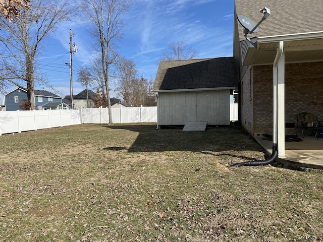 view of yard featuring fence private yard, a storage shed, and an outdoor structure