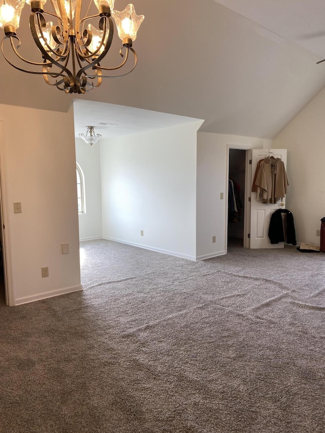 carpeted empty room featuring an inviting chandelier, baseboards, and vaulted ceiling