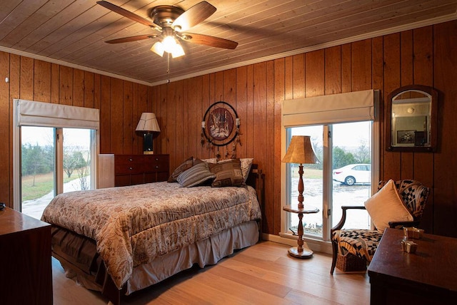 bedroom with ceiling fan, wood walls, access to exterior, and wood ceiling