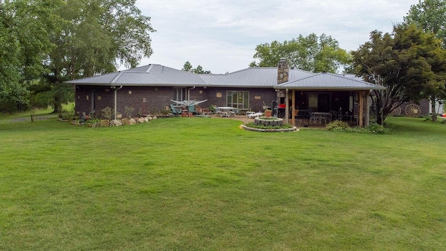 rear view of property featuring a yard and a patio