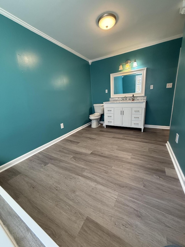 bathroom with vanity, hardwood / wood-style floors, ornamental molding, and toilet