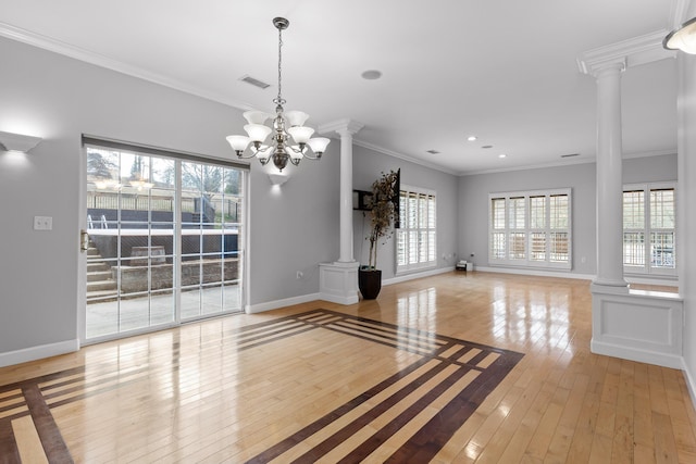 unfurnished living room with ornamental molding, light hardwood / wood-style floors, a chandelier, and ornate columns