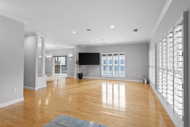 unfurnished living room with ornamental molding, light wood-type flooring, and ornate columns