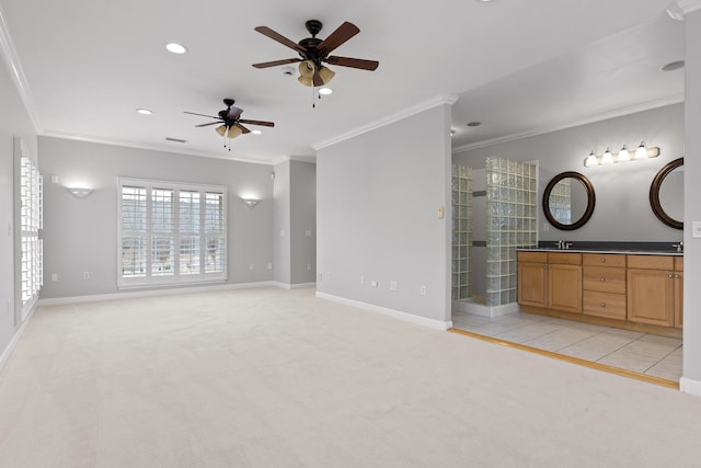 interior space with light carpet, sink, ornamental molding, and ceiling fan