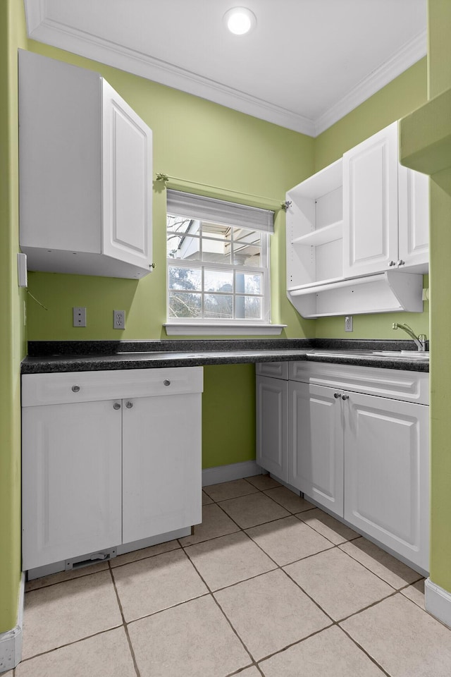 kitchen featuring white cabinetry, sink, crown molding, and light tile patterned floors