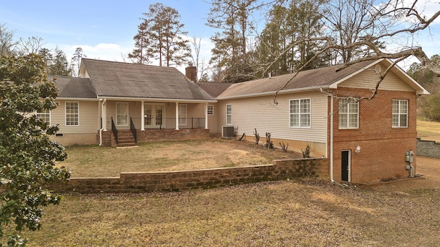 back of property with french doors, a yard, and central air condition unit