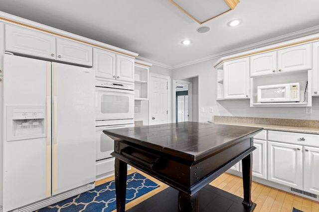 kitchen with crown molding, white appliances, and white cabinets