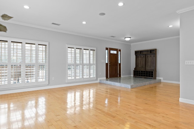 unfurnished living room featuring crown molding and light wood-type flooring