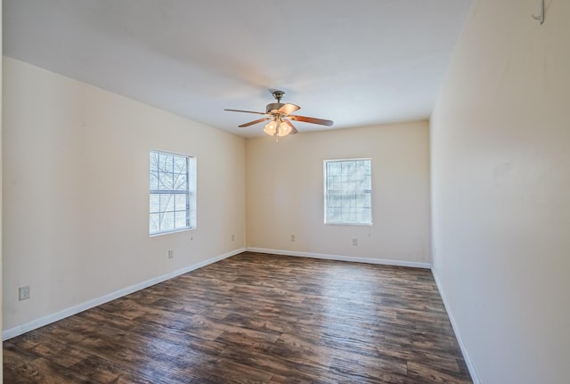 empty room with a healthy amount of sunlight, baseboards, and dark wood-style flooring