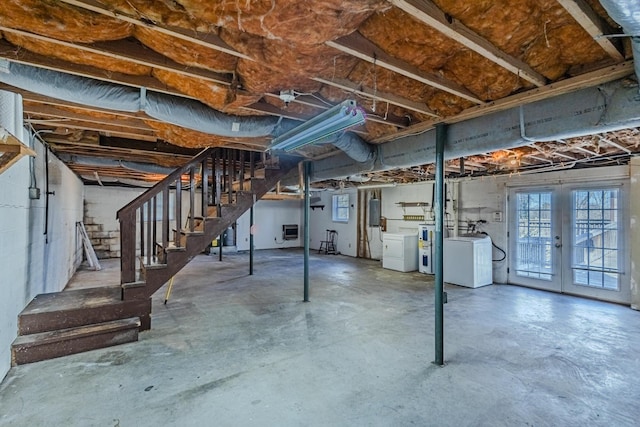 basement featuring electric panel, washing machine and dryer, stairs, and french doors