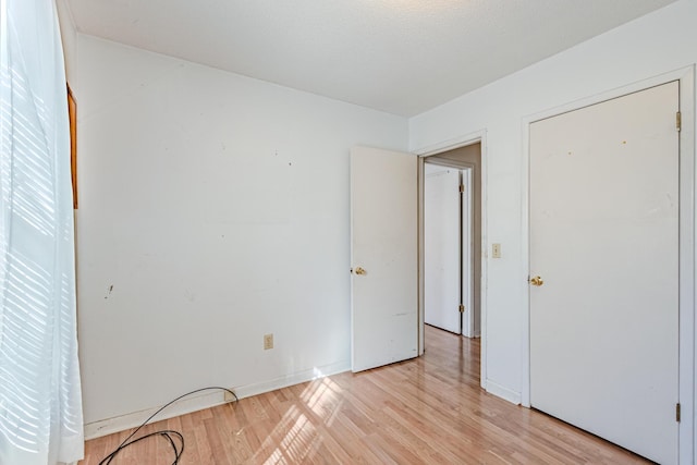 unfurnished bedroom with light wood-style floors and baseboards