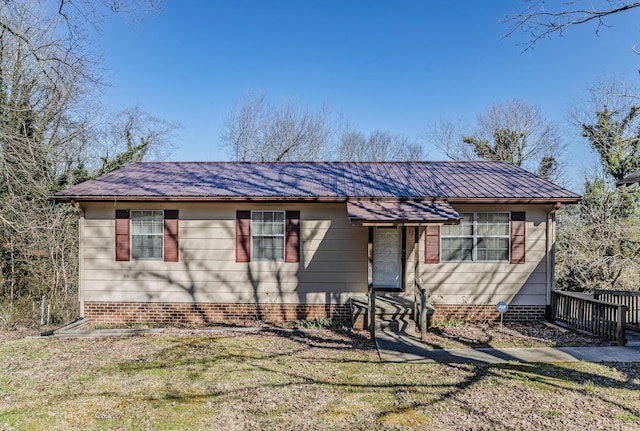 view of front of property featuring a front lawn and metal roof