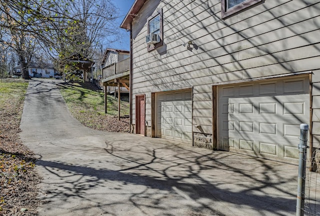 view of side of property featuring a garage, cooling unit, and a wooden deck