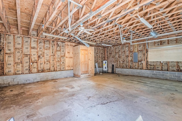 garage with water heater, electric panel, and concrete block wall