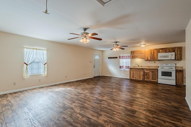 interior space with white appliances, dark wood-style flooring, a sink, baseboards, and light countertops