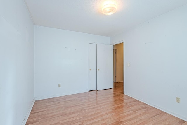 unfurnished room with baseboards and light wood-style floors