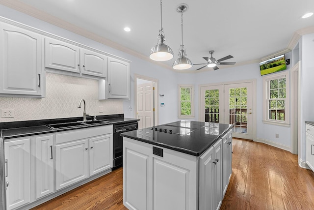 kitchen with a sink, black appliances, a ceiling fan, dark countertops, and light wood-style floors