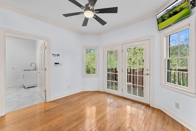 entryway featuring ceiling fan, ornamental molding, baseboards, and light wood-style flooring