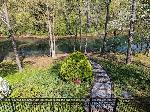 view of yard featuring a water view and fence