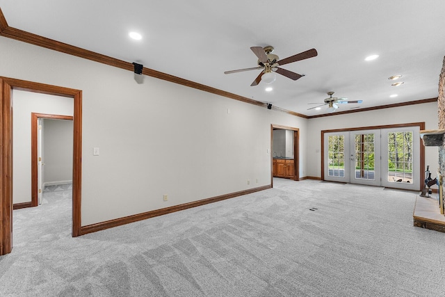 unfurnished living room with crown molding, light carpet, baseboards, and ceiling fan
